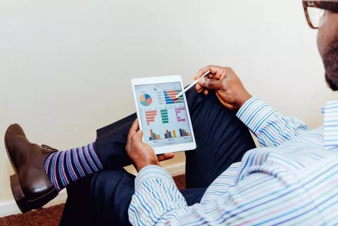 Ein Mann nutzt auf einem Tablet die Senec-App zur Kontrolle seines Strom-Cloud-Guthabens.